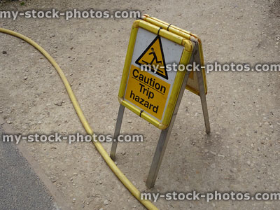 Stock image of folding A frame sandwich board sign, hose pipe 'tripping hazard'