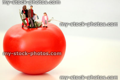 Stock image of healthy eating concept, with a family walking on a tomato