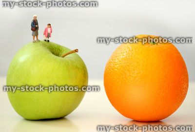 Stock image of healthy eating concept, with family of mini people on fruit