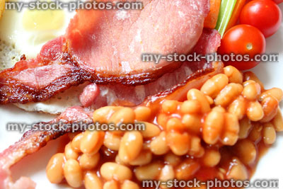 Stock image of low calorie, full English fried breakfast, healthy raw vegetables, baked beans, tomatoes, bacon