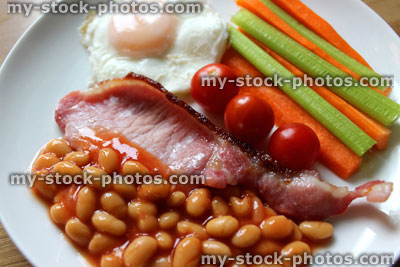Stock image of low calorie, healthy fried breakfast, bacon, poached egg, raw vegetables, tomatoes, baked beans