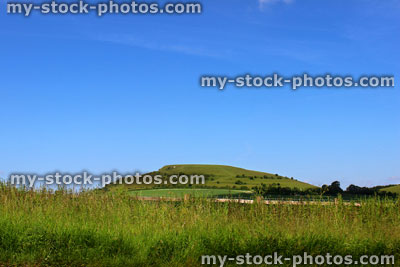 Stock image of steep hill in countryside, with grass, green fields