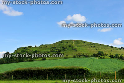 Stock image of steep hill in countryside, with grass, green fields
