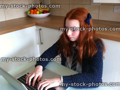 Stock image of girl doing homework on a laptop computer