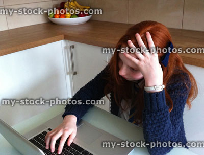 Stock image of girl struggling with homework using Apple laptop