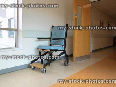 Stock image of NHS Hospital Corridor, cushioned wheelchair seat with wheels