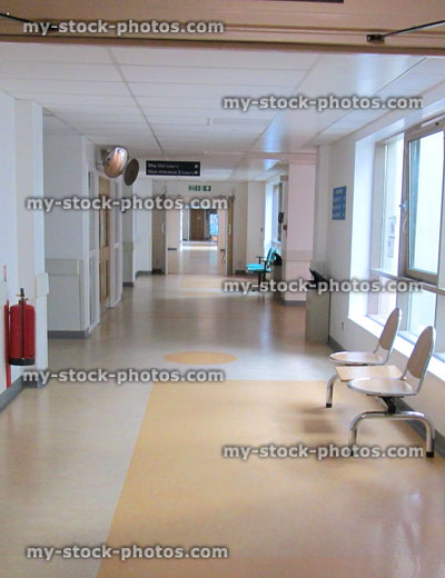 Stock image of hospital corridor with seating, beige vinyl flooring, fire extinguisher