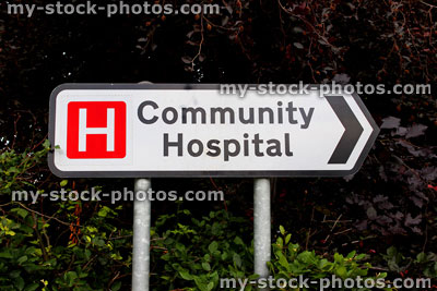 Stock image of white road sign / signpost pointing to Community Hospital