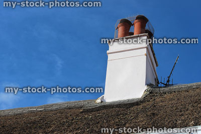 Stock image of chimney pots covered with chicken wire, stopping birds