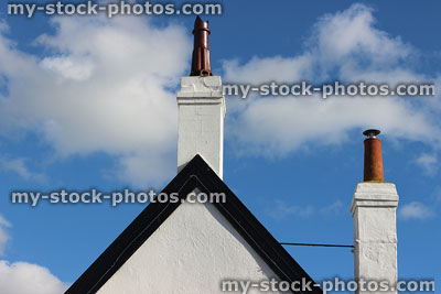 Stock image of rendered house apex painted white, fascia boards, terracotta clay chimneys