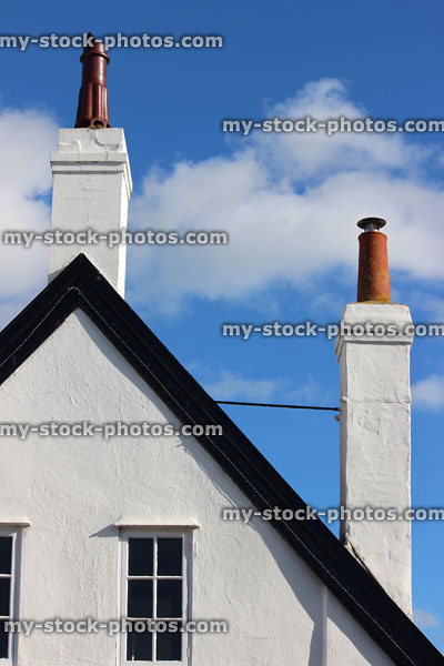 Stock image of house with render painted white, tall chimneys braced