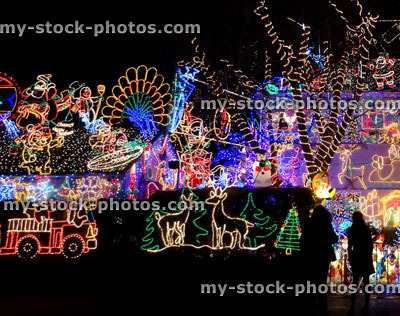 Stock image of people looking at house with colourful Christmas lights / decorations, night