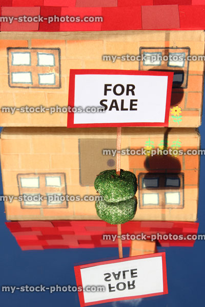 Stock image of cardboard model house, For Sale / Sold sign, reflecting mirror, real estate agent