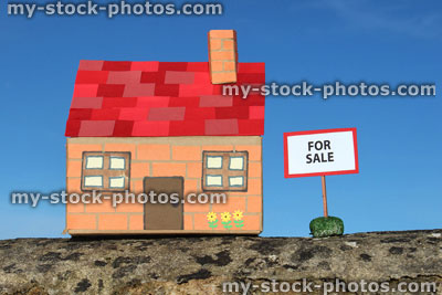 Stock image of cardboard model house, For Sale / Sold sign, real estate, estate agent, property