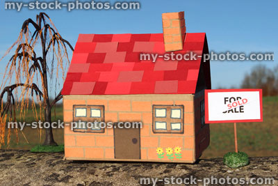 Stock image of cardboard model house, For Sale / Sold sign, real estate, estate agent, property, weeping willow