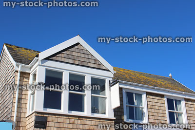 Stock image of seaside house with wooden shingles on wall, slate roof