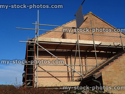 Stock image of modern red brick house with scaffolding poles erected, house repairs
