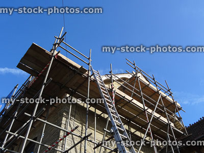 Stock image of house renovation, scaffolding poles / wooden planks and platforms
