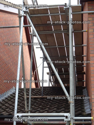 Stock image of metal scaffolding poles on garage roof, building work