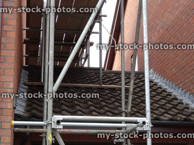 Stock image of scaffolding tubes / construction tower on garage roof tiles, 