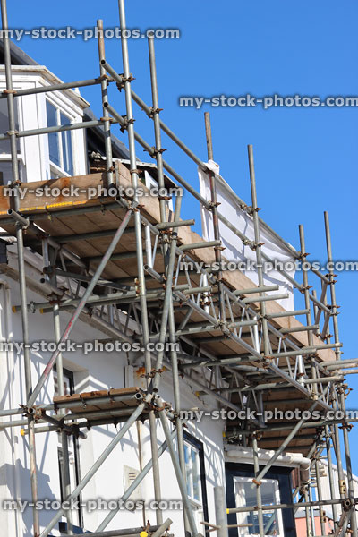 Stock image of house repairs to wooden windows, scaffolding tower / platform