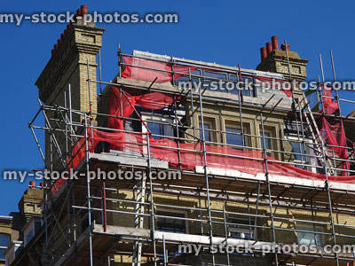 Stock image of builder's scaffolding tower against house roof / roofing repairs