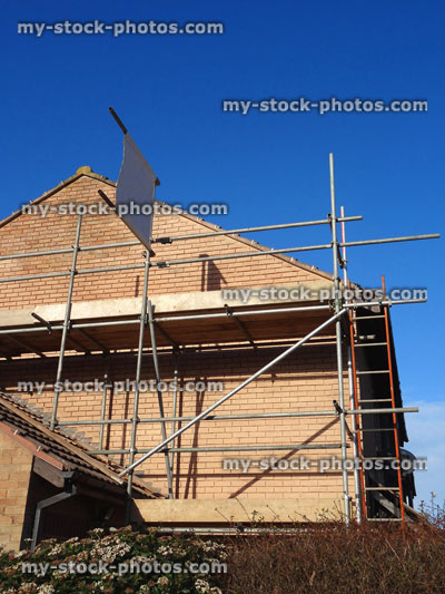 Stock image of modern red brick house with scaffolding poles erected, house repairs