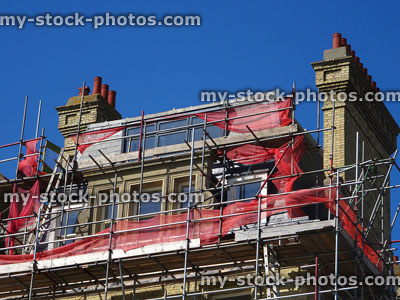 Stock image of scaffolding around roof tiles, chimney and roofing repairs