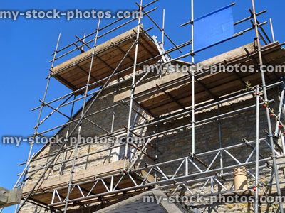 Stock image of stone wall repointing and roofing repairs with scaffolding