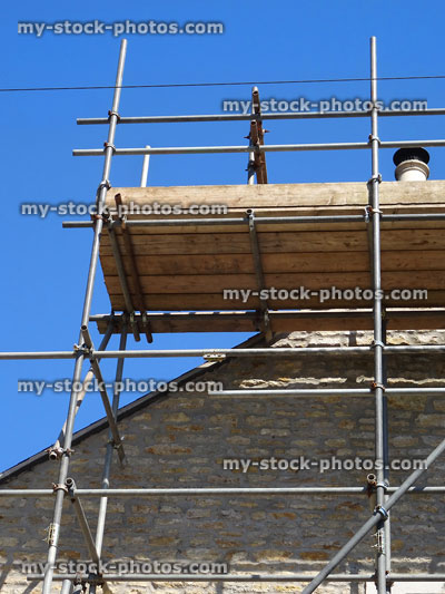 Stock image of builder's scaffolding poles and planks, wooden platform, roofing repairs