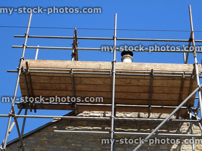 Stock image of scaffolding planks forming platform for roofing repairs, roof tiles