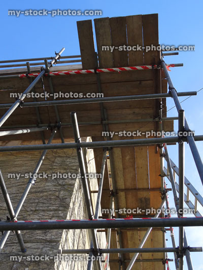 Stock image of house being repaired / restored, scaffolding poles and planks