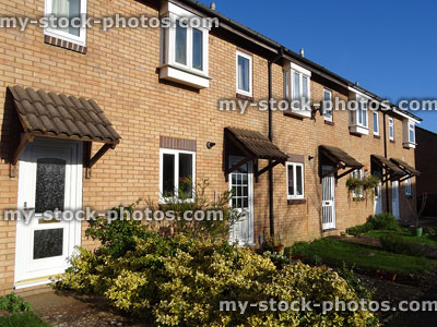 Stock image of modern terraced brick houses, white UPVC windows, doors