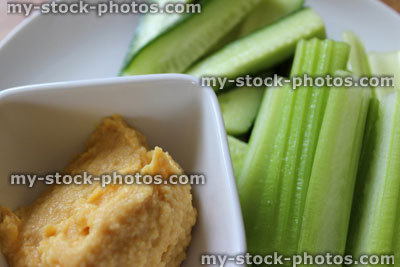 Stock image of hummus dip with celery / cucumber sticks, healthy eating / diet food