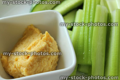 Stock image of hummus dip with celery / cucumber sticks, healthy eating / diet food