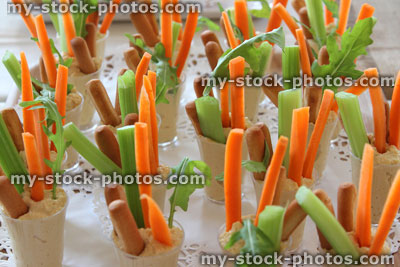 Stock image of hummus, carrot sticks, celery, breadsticks, party food buffet