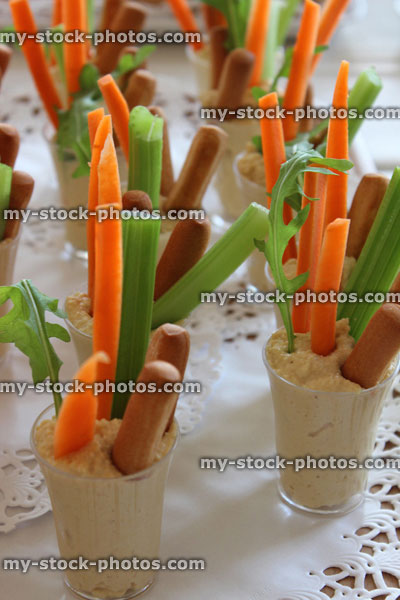 Stock image of hummus, carrot sticks, celery, breadsticks, party food buffet