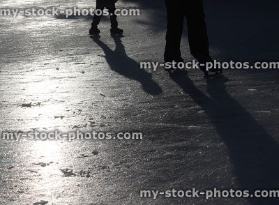 Stock image of outdoor ice skating rink at night, with skaters