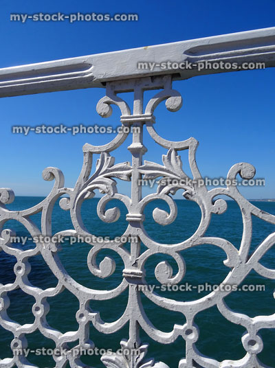 Stock image of seaside iron railings painted white, sea in background
