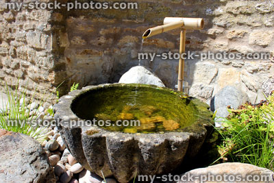 Stock image of stone water basin with bamboo fountain in Japanese Zen garden