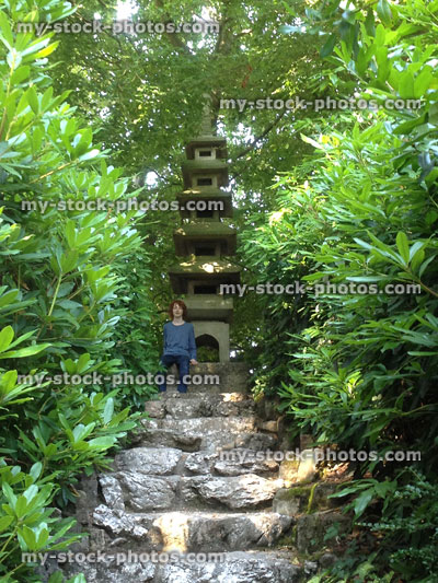 Stock image of boy sat next to pagoda in Japanese gardens