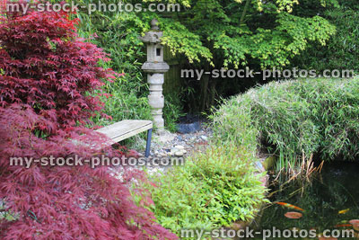 Stock image of Japanese garden with koi pond, granite lantern, maple and bamboo