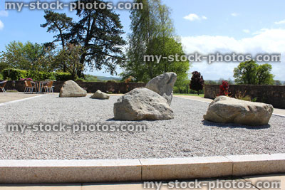 Stock image of Japanese Zen garden with stones, gravel, lanterns, maples
