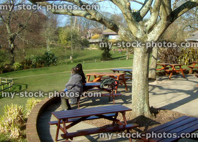 Stock image of wooden picnic tables outside restaurant, al fresco dining