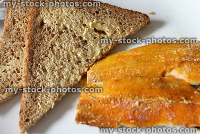Stock image of kipper and butter for breakfast (smoked / cured herring), wholemeal bread