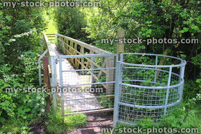 Stock image of metal kissing gate and wooden bridge, countryside walk