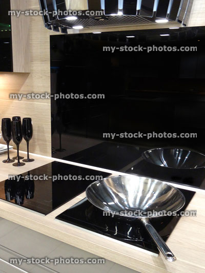 Stock image of modern kitchen, touch electric induction, built in ceramic hob cooker, drawers, glossy cabinets