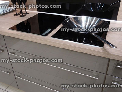 Stock image of modern kitchen, touch electric induction, built in ceramic hob cooker, drawers, glossy cabinets