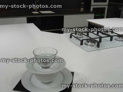 Stock image of modern monochrome, black / white kitchen, gas hob, corian worktop counter, island