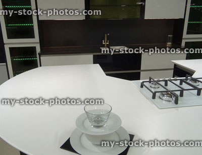 Stock image of modern monochrome, black / white kitchen, gas hob, corian worktop counter, island